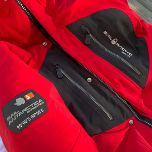 Sail Racing vinterjacka GORE-TEX gås fjädrar röd dam - Som NY, knappt använd! Priset går att sänkas :) Kontakta mig för fler bilder. Vinterjacka i GORE-TEX® 2-lagers stretchtyg, håller dig varm o. torr i tufft väder. Gås fjädrar! 7 st fickor, fyra utanpå och tre inuti inklusive en gömd.Butikpris: 7000kr