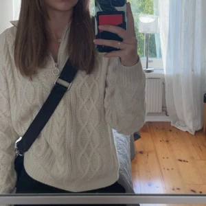 Vit stickad tröja med kabelmönster - Säljer en superfin, trendig, beige stickad halv zip tröja med kabelmönster. Den har en mysig och varm känsla, perfekt för kyligare dagar.🍂🌧️från b.young, köpes för runt 500 lappen