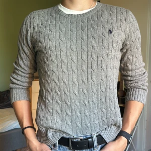 Ralph Lauren stickad - Riktigt snygg och fräsch kabelstickad tröja från Ralph Lauren. Storlek L men passar som XS. Passar dig som är ca 170cm. Nyskick, nästan inga spår av användning. Inte nopprig eller slitage.  Perfekt till hösten. Pris kan diskuteras vid snabb affär.