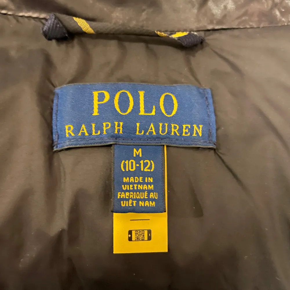 Säljer en snygg svart pufferjacka från Polo Ralph Lauren. Jackan har en glansig finish och är perfekt för kalla dagar. Den har en praktisk huva och flera dragkedjefickor för förvaring. Jackan är i storlek M i barnstorlek, och är i ett bra skick ✅. Jackor.