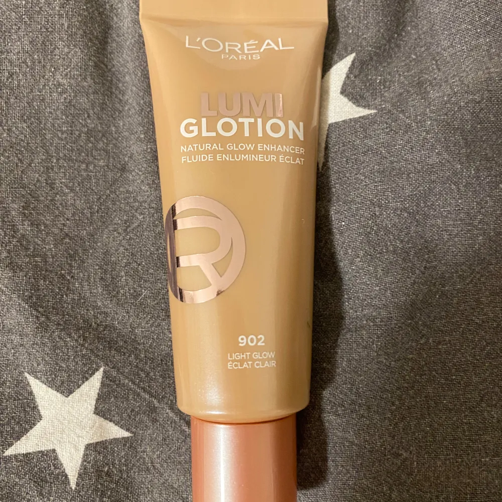 Säljer en L'Oréal Paris Lumi Glotion i nyansen 902 Light Glow. Denna produkt är en naturlig glow enhancer som ger huden en strålande lyster. Perfekt för att få en fräsch och glödande look!. Skönhet.