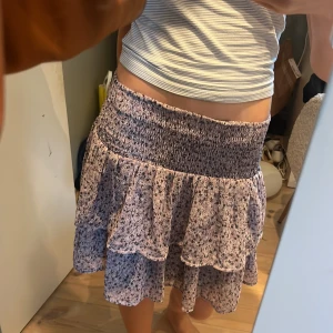 Söt Stockholmsstil kjol - Fin Stockholmsstil kjol i en lila färg med blommor på från Kappahl. Storlek 158/164 cm men passar xs-s. Stretchigt material, så skön. Har en svart underkjol så den är absolut inte genomskinlig. Använd få gånger, superbra skick. KOLLA MIN PROFIL💍❤️🪻