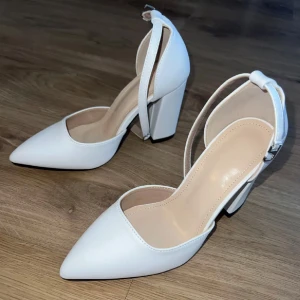 Vita klackar - Vita klackar ca 9cm höga. Endast testade, aldrig använda pga för stora. Dom är i storlek 35 men jag skulle säga att dom är en 35.5.