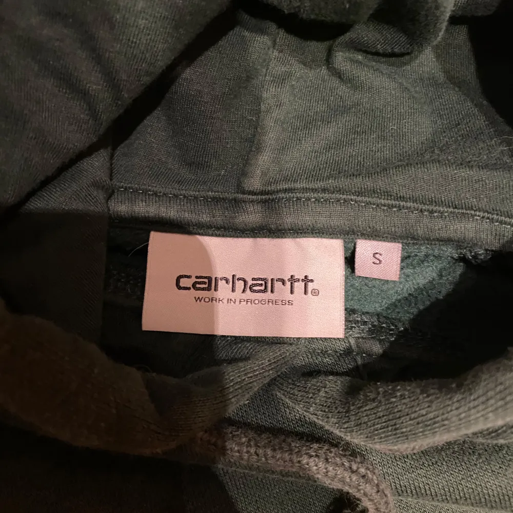 Säljer äkta mörkgrön Carhartt hoodie. Har liten ljusare fläck på framsida som kan ses på bilden.   - Storlek S - Längd 65cm x axelbredd 55cm - Normal i storleken (är själv 158cm) - Mycket bra skick  Skriv i PM vid frågor/köp🫶. Hoodies.