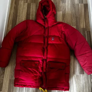 Fjällrävenjacka  - Röd fjällrävenjacka som är supermysig och härlig!! Säljer pga fel storlek för mig, har en liten slitning på ryggen men har ”laglappar” från naturkompaniet som hör till jackan! 