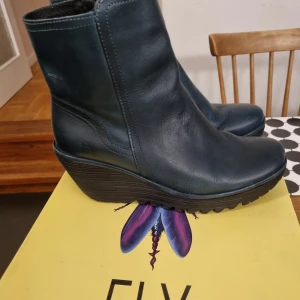 Fly London boots strl 39 - YETI907FLY blue strl 39. Ankelboots i skinn. Endast använda några ggr. Helt felfria. Mycket sköna!! Orginalkartong. Mörkt blå/petrol 