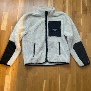 Calvin Klein fleecejacka - I fint skick, lite noppror på ärmslut som syns på bild 3 men de går att rycka bort. Storlek 12 i barnstorlek. Pris 300:-