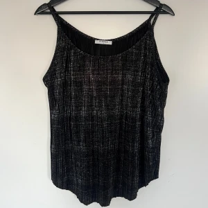 Glittrigt plisserat linne - Svart silverglittrigt plisserat linne i storlek M från Pieces. Använd ett fåtal gånger så är fortfarande i väldigt bra skick. 