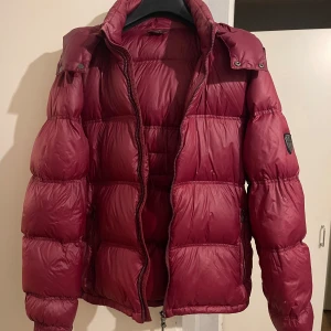 Röd pufferjacka - Säljer en snygg röd jacka. Jackan har 2 dragkedjor framtill och är Inte i det bästa skicket men ändå ok. Finns ingen storlek men skulle säga att den passar storlekar runt M. ❤️