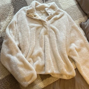 H&M fleece tröja, storlek L - Mjuk och mysig fleece med knappar framtill. Tröjan har en bekväm passform och en härlig, fluffig textur. Perfekt för kallare dagar eller som en extra lager på lager outfit. Sparsamt använd och i mycket gott skick. Storlek L