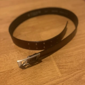 Brunt skärp från Tiger of Sweden - Snyggt brunt skärp i äkta läder från Tiger of Sweden. Stilren design med ett fyrkantigt silverfärgat spänne💖💞 85cm