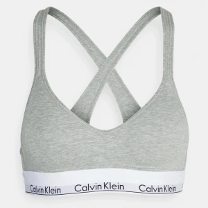 Calvin Klein bh - Säljer en grå Calvin Klein bralette med korsade axelband. Endast testad, helt ny! Lapparna kvar. Säljer då den var för liten