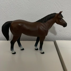 Wild safari häst - Detaljerad brun hästfigur med svart man och svans. Benen har en gradvis övergång från brunt till svart, vilket ger en realistisk look. Perfekt för samlare eller som dekoration.
