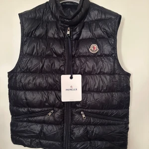 Moncler  - Moncler Gui väst. Storlek 2 motsvarar M/S. Super fint skick, tillkommer kvitto tags samt dustbag. Pris 3590kr. Färg marinblå