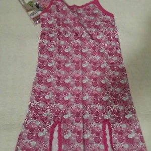 Rosa blommig klänning - Söt rosa klänning med blommigt mönster och smala axelband. Perfekt för en avslappnad dag hemma eller som ett bekvämt nattlinne. Den har en fin spetsdetalj vid halsringningen och är knälång.