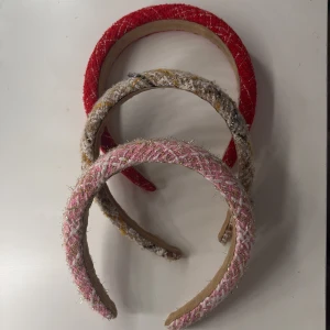 Färgglada diadem i olika mönster - Säljer tre snygga diadem i olika färger och mönster. Ett rött diadem med ett glittrigt mönster, ett rosa diadem med guldiga detaljer och ett beige diadem med med olika mönster!💕15 kr för alla!💕