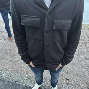 Svart overshirt med knappar - Säljer en svart overshirt. Har använt den fåtal gånger på sistone de. Skicken är 9/10. Storlek S men kan även passa XS