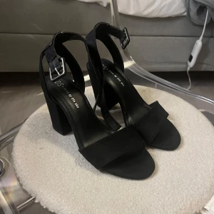 Svarta klackar från DS - Snygga svarta klackar från DS.  Använda 2 gånger!  De har en bred rem över tårna och justerbart spänne runt ankeln.   Säljer då jag behöver rensa bland skor.  Mycket bra skick!   Storlek: 35/36.  Kontakta mig vid frågor eller för fler bilder.