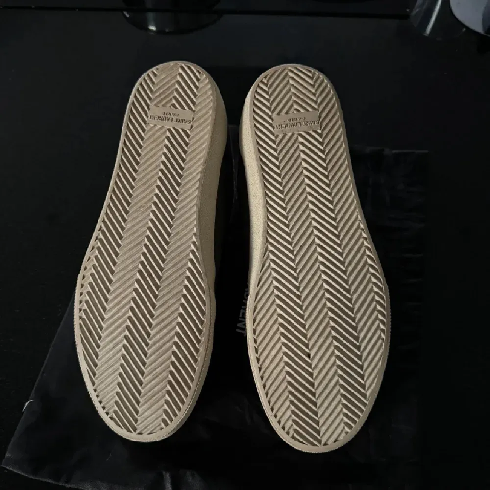 Snygga grå sneakers från Saint Laurent med vit sula och snörning. Skorna har en stilren design med Saint Laurent-logga på sidan.. Kengät.