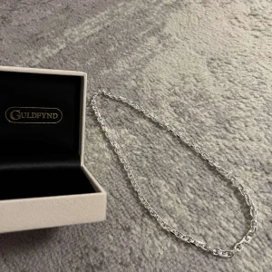 ANKARLÄNK I ÄKTA SILVER (50 CM) - ANKARLÄNK I ÄKTA SILVER 50 CM Bredd ca (mm): 5.5 Längd ca (cm): 50 Varumärke: Guldfynd Material: Silver.                                                                 Hej! jag säljer nu mitt superfina ankarlänk. Köptes för ca 3 veckor sedan och använts ett par gånger endast. Den är som sprillans ny och gjort av det finaste silvret av guldfynd. Köptes för fullpris 1 898kr men säljer det till ett billigare pris då jag vill få det sålt och köpa något annat. 