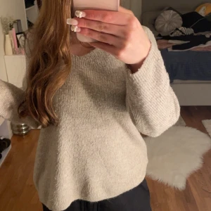 Beige stickad tröja från Vero Moda - Mysig beige stickad tröja från Vero Moda med v-ringning. Perfekt för kyliga dagar med sin mjuka och bekväma passform. Långärmad design som passar till många olika outfits.