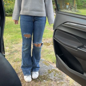 Lågmidajde jeans med håll - Snygga låg/mid waist bootcut jeans med egen gjorda håll! Säljer vid snabb affär för vill annars gärna behålla🙈 Super trendiga och lätt att styla! Lite små defekter vid hälarna men inget man tänker på.