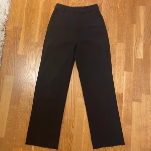 Svarta kostymbyxor från Gina Tricot - Raka kostymbyxor ifrån Gina, storlek 32 men stora i storleken så passar 34. Uppsprättade för att de skulle bli längre. 