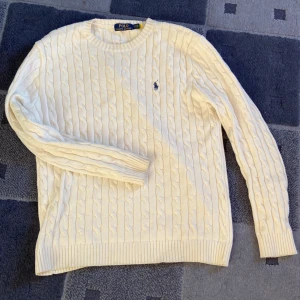 Vit stickad tröja från Polo Ralph Lauren - Säljer en klassisk vit stickad tröja från Polo Ralph Lauren då den inte används! Tröjan har långa ärmar och en rund halsringning. Perfekt för en stilren och tidlös look. Pris går att diskutera vid ett snabbt köp!