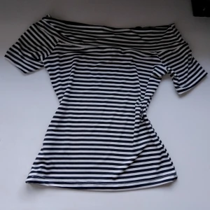 Randig offshoulder topp från H&M - En randig, figurnära topp med korta ärmar. Kommer från H&M, aldrig använd 