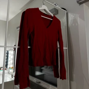 Vinröd tröja med v-ringning - Snygg vinröd tröja med v-ringad hals och långa ärmar. Perfekt för kyligare dagar och kan enkelt matchas med olika outfits.
