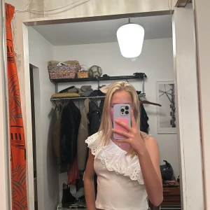 Vit oneshoulder topp med spetsdetaljer - Snygg vit oneshoulder topp med vacker spetsdetalj längs axeln. Köpt från Zara, st 152 cm.💓 säljer pga att den är för liten💕