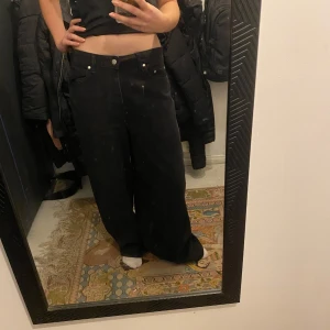 Svarta vida byxor - Säljer ett par svarta byxor med en loose passform. Byxorna är mid waist och är perfekta för en avslappnad stil. De har knappar och dragkedja framtill. Är långa på mig som är 170 