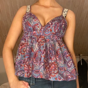 Mönstrad blus  - Säljer en färgglad blus med paisleymönster i lila, rött och blått. 