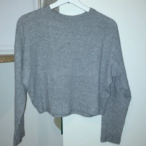 Grå tröja från H&M - Säljer en jättefin men också basic grå tröja från H&M. Tröjan är långärmad och har en enkel design som passar perfekt till vardags. Materialet är mjukt och bekvämt, vilket gör den idealisk för kyligare dagar. Tröjan är lite cropped🎀