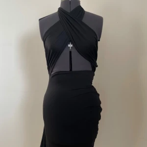 Svart klänning - Svart klänning med omlott-design.