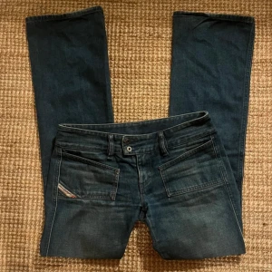 Mörkblå jeans från Diesel - Lånade bilder! Snygga lågmidjade bootcut  jeans från Diesel. Är i bra skick. Passar i längden på mig som är 163, skulle säga att de passar i längd upp till 165/166 cm . 