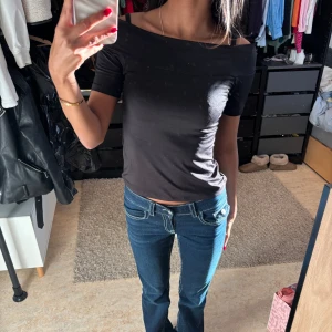 Svart offshoulder topp - Snygg svart offshoulder topp med korta ärmar. Perfekt för en stilren look. Passar bra till jeans eller kjol.