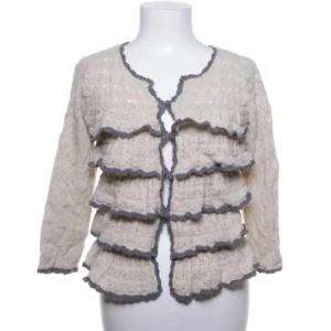 Trekvartsärmad beige kofta med volanger - Jättesöt trekvarsärmad beige kofta med volanger från Odd Molly. Storlek M men skulle snarare säga att den är i storlek S! Bara använd ett fåtal gånger.