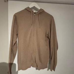 Beige hoodie från Lacrosse - Säljer en stilren beige hoodie från Lacrosse Premium Line. Tröjan har dragkedja och långa ärmar, perfekt för en avslappnad look. Den är mjuk och bekväm, idealisk för kyligare dagar.