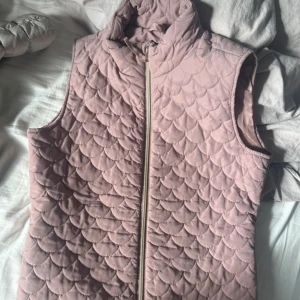 Rosa quiltad väst från Saint Tropez - Säljer en snygg rosa quiltad väst från Saint Tropez i storlek S. Västen har en dragkedja framtill och ett stilrent mönster. Perfekt för lager-på-lager under kyligare dagar.