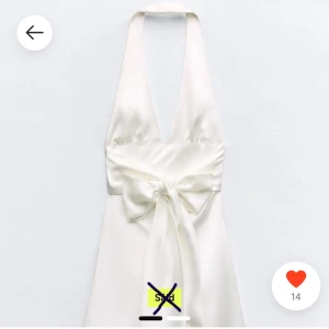 Studentklänning - Elegant vit axelbandslös klänning med v-ringad hals och knytning i midjan. Perfekt för sommarens festligheter. Klänningen har en mjuk och glansig yta som ger en lyxig känsla. Säljes då jag inte passade i den, köpt från en tjej från Plick som inte heller använt den därav prislappen kvar! Köptes med två millimeters jack längst ner på ena bandet men är inte märkbart!! Skriv för fler bilder!