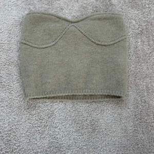 Beige stickad tubtopp - Säljer en stilren beige stickad tubtopp från Zara . Den har en enkel design med en mjuk och bekväm passform. Perfekt för lager-på-lager eller att bära som den är.