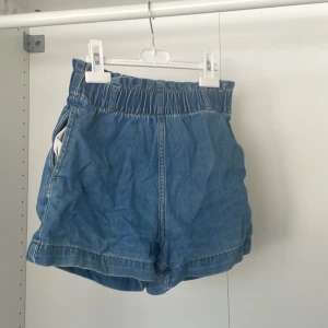 Blå jeansshorts från &Denim - Säljer ett par blå jeansshorts från &Denim. De har en elastisk midja för extra komfort och en avslappnad passform. Perfekta för varma sommardagar! 🌞