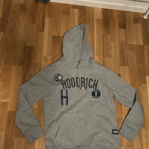 Grå Hoodrich hoodie - Säljer en snygg grå hoodie från Hoodrich med tryck på framsidan. Perfekt för en skön stil. Hör av dig vid intresse! Pris kan diskuteras!