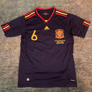 Spanien 2010 VM Fotbollströja - En mörkblå fotbollströja med Iniesta #6 på ryggen | Tröjan är i toppskick och bra kvalitet | Använd 2-3 gånger utan syn på användning