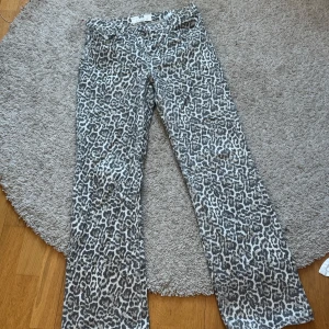 Leopardmönstrade byxor från stradivarius - Snygga leopardmönstrade byxor från Stradivarius i storlek 36. Byxorna har en klassisk femficksdesign och är perfekta för att ge din outfit en djärv touch. Tillverkade i Turkiet med en bekväm passform.