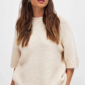 Beige stickad tröja - Mysig beige stickad tröja med trekvartsärm. Perfekt för kyligare dagar med sin mjuka och bekväma passform. Enkel och stilren design som passar till det mesta. Från Moa Mattsons kollektion med Nakd🥰🥰