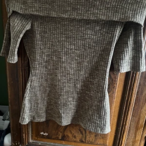 Beige ribbad off shoulder tröja från River Island - Snygg beige ribbad off shoulder tröja från River Island med knappar på axeln. Perfekt för en stilren look. Tröjan har en offshoulder-design och trekvartsärmar som ger en trendig touch.