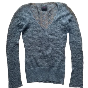 Grå stickad vintage glittrig tröja från Eve of Eden - Snygg grå stickad tröja från Eve of Eden med ett vackert mönster och v-ringning. Glittrig! Strl S 