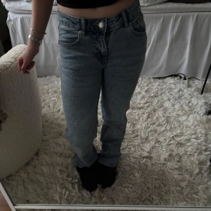 Blå jeans med rak passform - Snygga blå jeans med rak passform och klassisk femficksdesign. De har en knapp och dragkedja framtill och är perfekta för en avslappnad stil. Passar bra till både sneakers och boots.